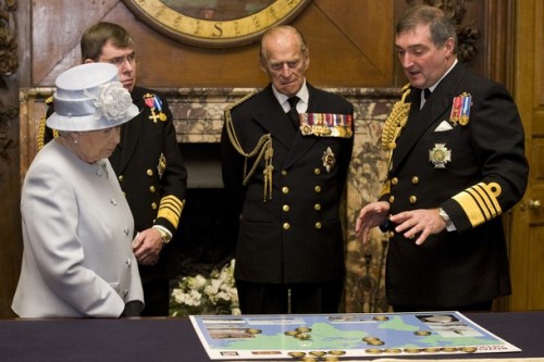 Queen Elizabeth II accompanied by First Sea Lord, Admiral Sir Mark Stanhope (2L) and her husband Prince Philip, Duke of Edinburgh, are shown a map detailing current naval deployments by Admiral Sir Trevor Soar (R) during a visit to the Admiralty Board and Admiralty House, November 23, 2011 (photo: Carl Court-WPA Pool/Getty Images)